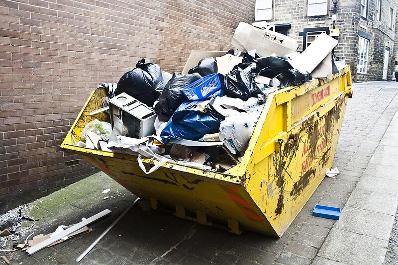A dump trailer being loaded with renovation debris