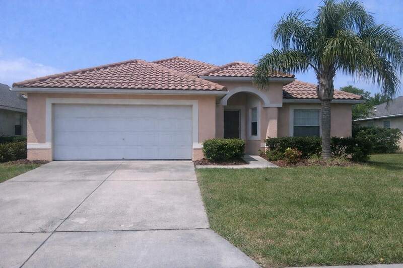 A single-story coral stucco house with a barrel tile roof and a queen palm in central Florida